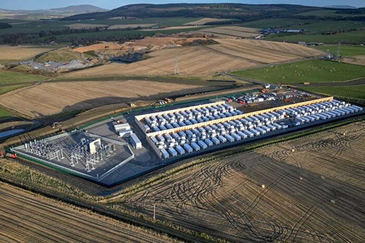 a large building with cars parked in a field