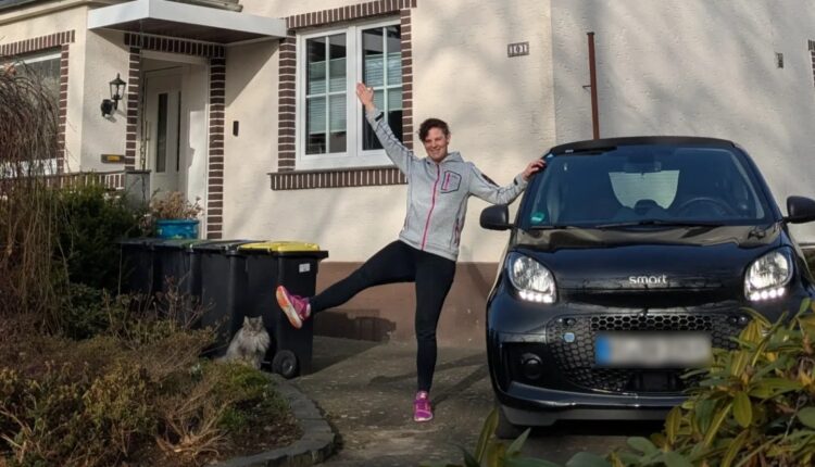 Mutmacherin Svenja mit Elektroauto vor Haus