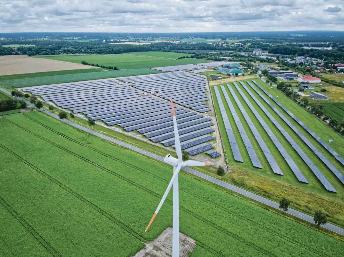 Drohnenaufnahme der Solarparks von Drewsen Spezialpapiere bei Lachendorf mit Windrad im Vordergrund