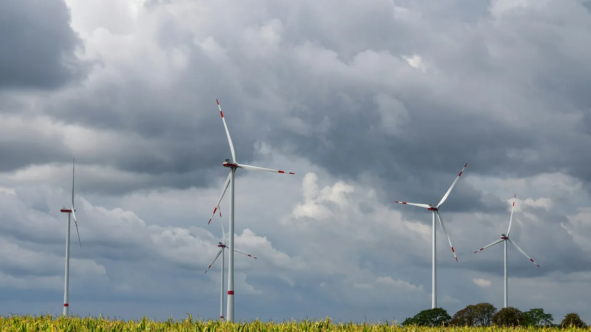 Windräder vor dunklen Wolken, Symbolbild für die neuen EU-Regeln für erneuerbare Energien