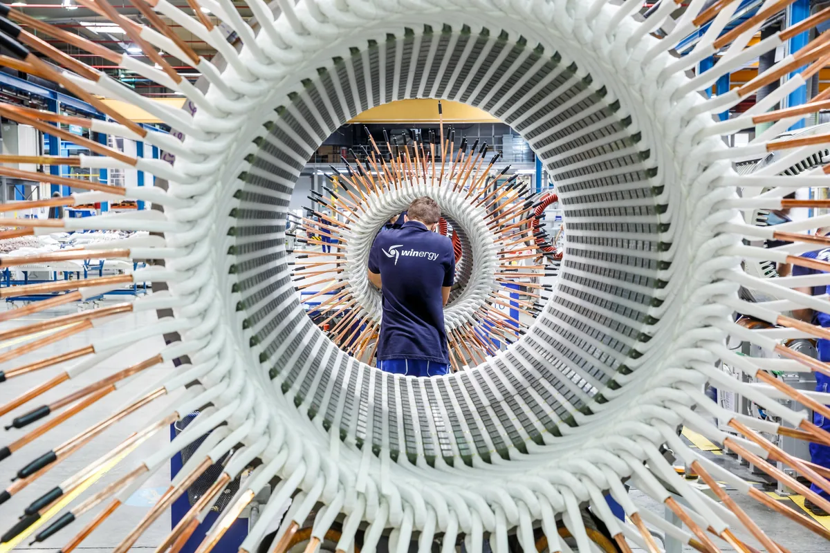 Mitarbeiter in der Winergy-Fertigung im Stator eines Windkraft-Generators mit Kupferwicklungen