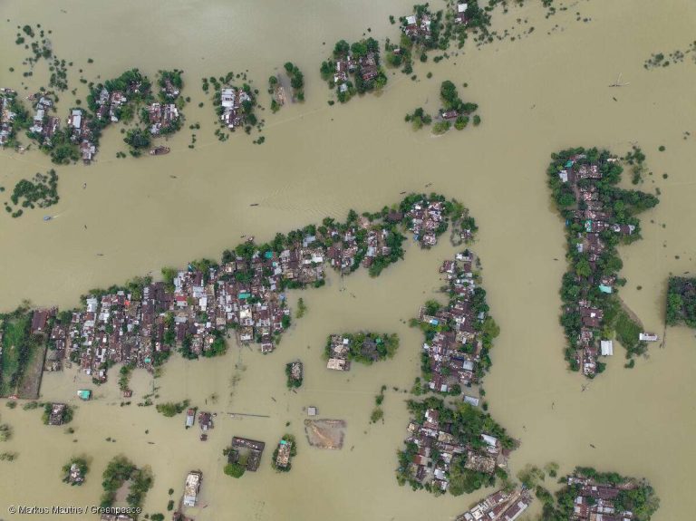Klimamigration: Luftaufnahme einer überschwemmten Siedlung in Bangladesh – Folgen des Klimawandels