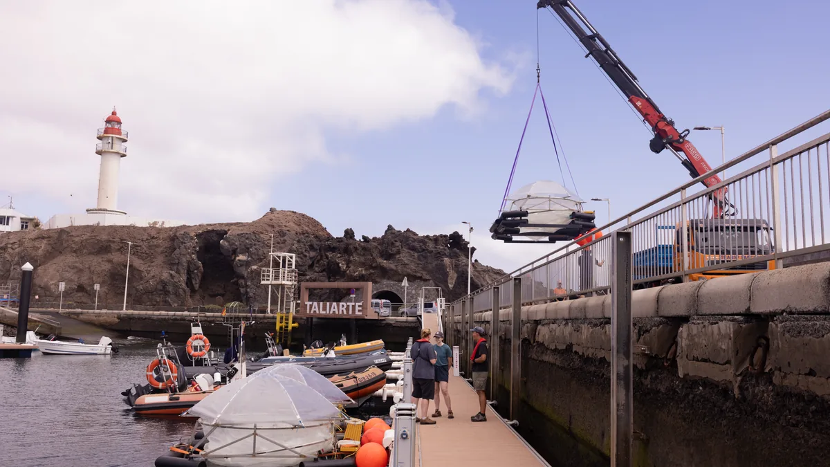 Ein Kran hebt einen Mesokosmos-Versuchsbehaelter der Ozean-Alkalinisierung im Hafen von Taliarte auf Gran Canaria