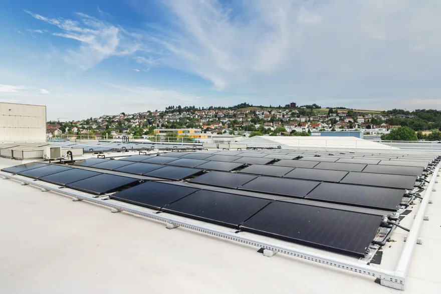 PVT-Hybridmodule von Sunmaxx auf dem Flachdach des Mahle-Werks in Vaihingen an der Enz, im Hintergrund Wohnhäuser am Hang
