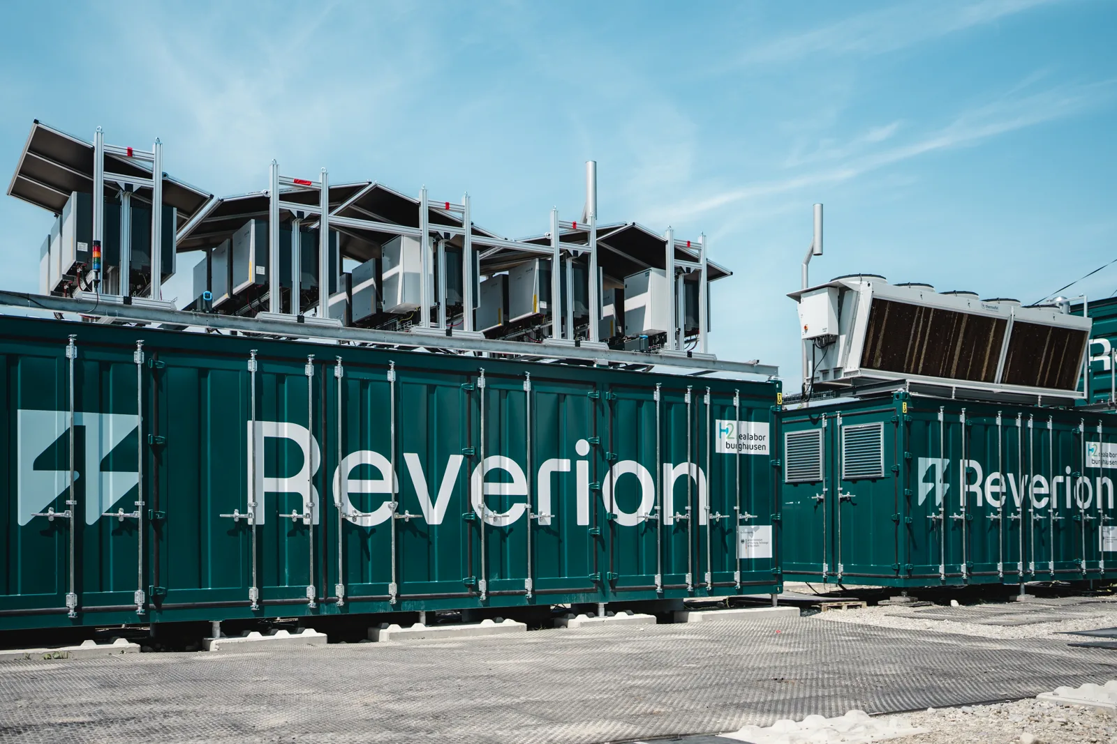 Flexible Kraftwerke von Reverion in grünen Containern mit Kühlaggregaten auf dem Dach
