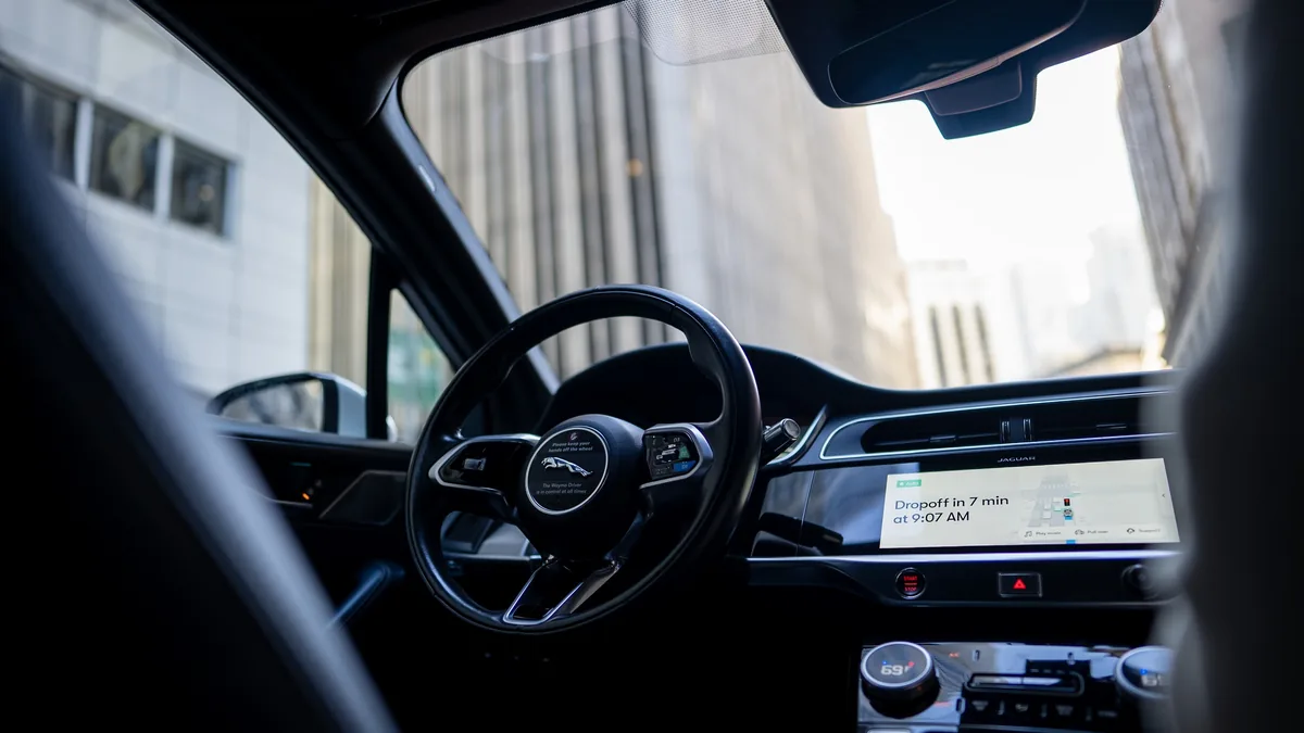Waymo München: Cockpit eines Jaguar I-Pace Robotaxi mit Lenkrad und Zielanzeige auf dem Display